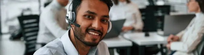 Smiling IT consultant in a customer support setting, highlighting Exigo Tech's Professional Services delivery model in Australia for strategic guidance and IT solutions Smiling IT consultant in a customer support setting, highlighting Exigo Tech's Professional Services delivery model in Australia for strategic guidance and IT solutions