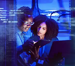 Professionals collaborating on a computer, discussing Zero Trust security assessment